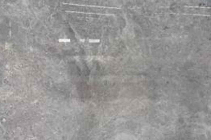 Mesa de centro de mármol con nervaduras grises y sofá largo